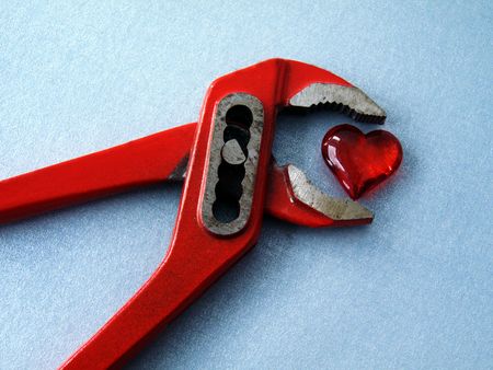 heart with pliers on the silvery background の写真素材