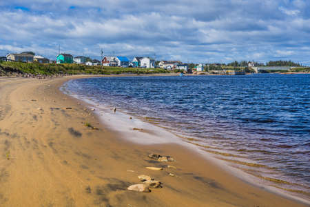 Sandy beach of Aguanish on a summer day, with the small fishing town of Aguanish in the beackground, located in Cote Nord region of Quebec, Canadaのeditorial素材