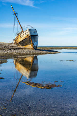 Reflection of the "Calou" shipwreck on a clear summer morning on Anticosti island, an island located in the St Lawrence river, in Cote Nord region of Quebec, Canadaのeditorial素材