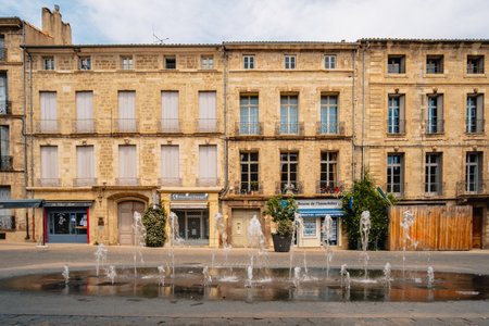 Fountain and beautiful stone facades of the Cours Jean Jaures street in the old town of Pezenas in the south of France (Herault)のeditorial素材