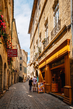 Quaint shops and facades on the cobblestone paved street of Rue de la foire in the old medieval town of Pezenas in the south of France (Herault)のeditorial素材