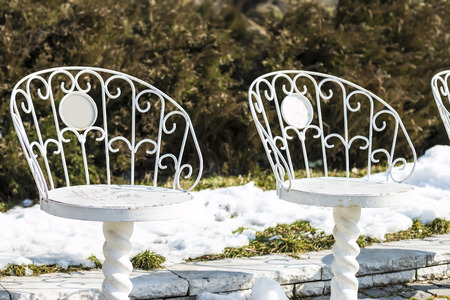 The empty white iron chairs in winter parkの写真素材