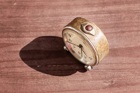 Old vintage alarm clock on wooden desk
