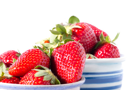 fresh red strawberries on white cup and white backgroundの写真素材