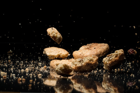 Falling Sweet Cookies On Black Background With Reflectionの写真素材