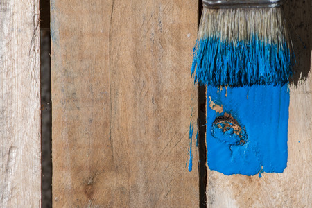 Closeup of pine plank being painted in a blue colour, with copy spaceの写真素材