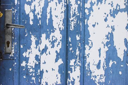 Old blue wooden door with peeling paintの写真素材