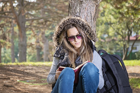 Portrait of attractive young girl with book in a parkの写真素材