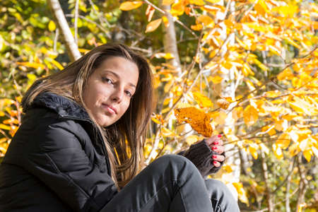 Portrait of a young woman in autumn parkの写真素材