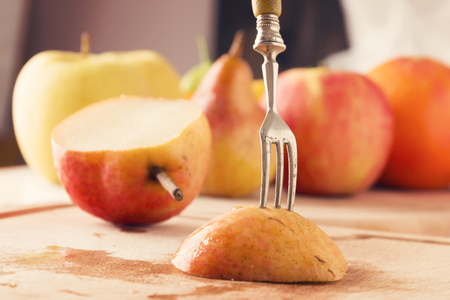 Piece of fresh pear pierced on a  forkの写真素材
