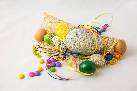 Stone and colored eggs on the white background