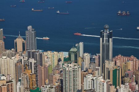Skyscraper in the centre of Hong Kong. Boats and ferrys on the sea.