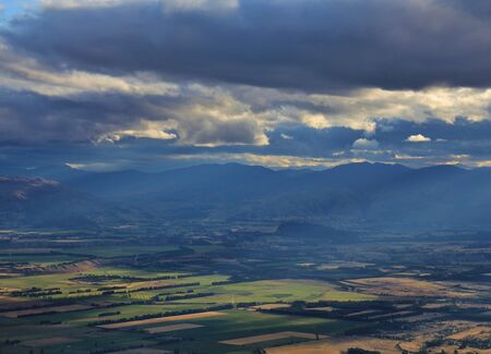Rural landscape on the South Island. Sunlight breaking trough clouds. Scene in Hawea.