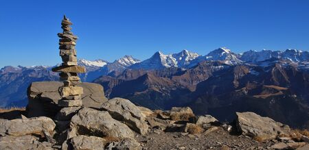 Cairn on top of mount Niesen. View of the famous mountains Eiger, Monch and Jungfrau. Autumn day in...