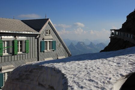 Spring day on Mount Santis. Snow field, old hotel and Churfirsten Range. Travel destination in the Swiss Alps.のeditorial素材