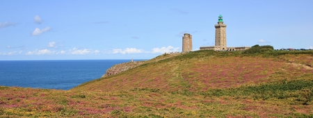 Old lighthouse and flowers at Cap Frehel, Brittany. Popular landmark at the French Coast. English Channel.の写真素材