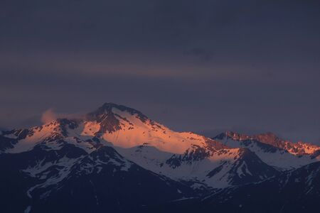 Last sunlight of the day touching the peak of Mount Hoch Ducan, Canton of Grisons, Switzerland.