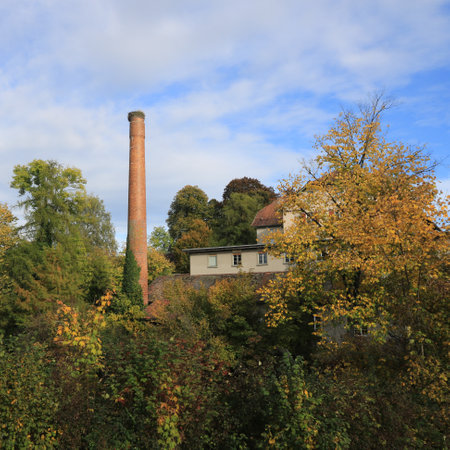 Brich chimney, old factory Schoenau surrounded by colorful trees.の写真素材