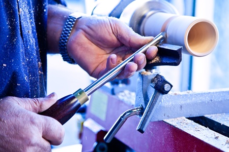 Old worker hands at lathe
