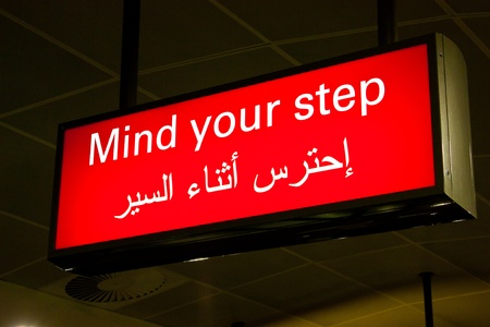 Mind your step sign in an international airport in Middle East with Arabic informationの写真素材