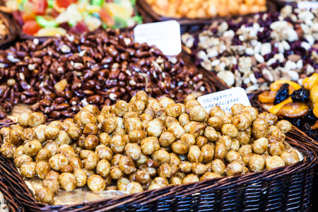 Interior of a busy food market, with detail on peanuts and almonds basketsの写真素材