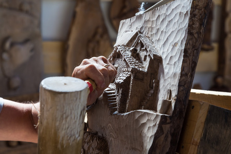 Detail of caucasian middle aged scultor working on wood, natural daylight