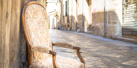 Lecce town, Italy. Vintage chair with old town street in background.の写真素材