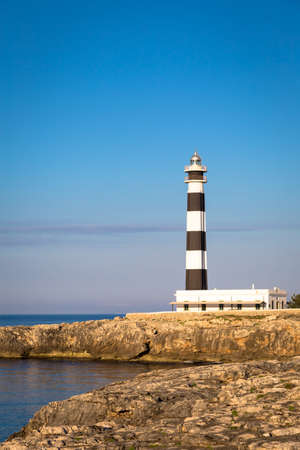 MINORCA ISLE - SPAIN - CIRCA AUGUST 2020: scenic Artrutx Lighthouse at sunset, famous landmark of the Isleのeditorial素材