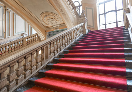 Turin, Italy - January 2023: Palazzo Barolo staircase. Luxury palace with old baroque interior and red carpetのeditorial素材