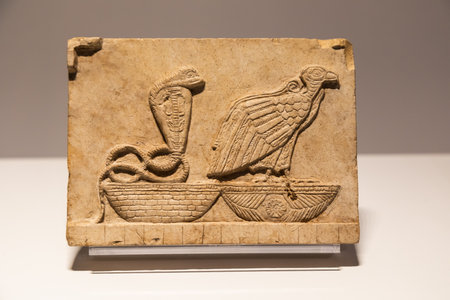 Turin, Italy - 28 December 2023: Egyptian Museum. Plaque with vulture and cobra, limestone, 400 BCのeditorial素材