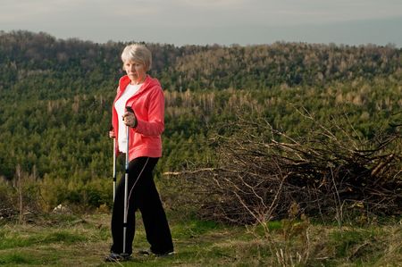 Senior woman train nordic walkingの写真素材