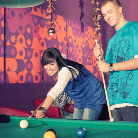Young people playing billiards in the clubの写真素材
