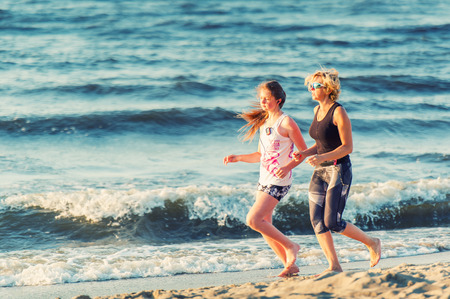 Mother and daughter runs In the Baltic Seaの写真素材