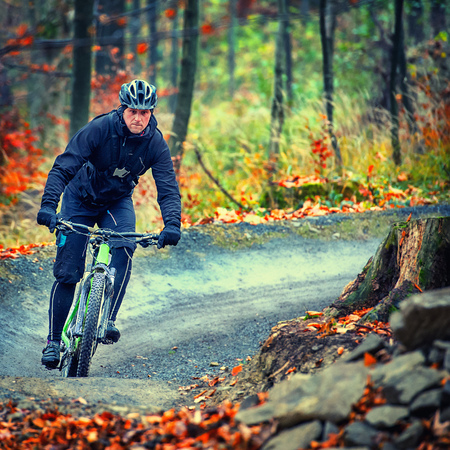 mountain biker riding in autumn forestの写真素材