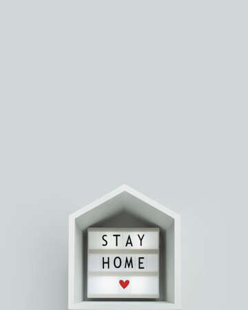 stay home lettering on a lightbox with wooden house