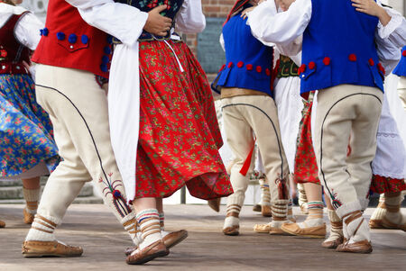 Horizontal colour image of female polish dancers in traditional folklore costumes on stageの写真素材
