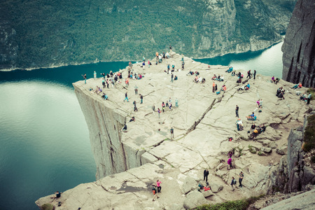 NORWAY - JUNE 2, 2012: unidentified group of tourists enjoy breathtaking views from Preikestolen rockのeditorial素材