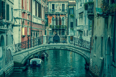 view into a small canal in Venice at nightの写真素材