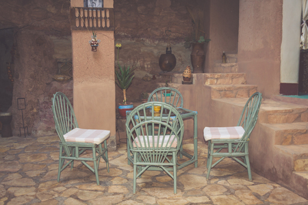Street view of a empty coffee terrace with tables and chairs in old town of Marrakech, Morocco.