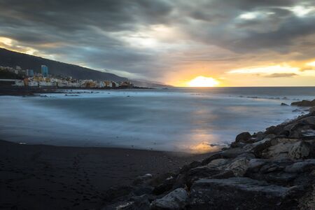 Black pebble beach in Puerto de la Cruz by the sunset , Tenerife, Canary Islands Spainの写真素材