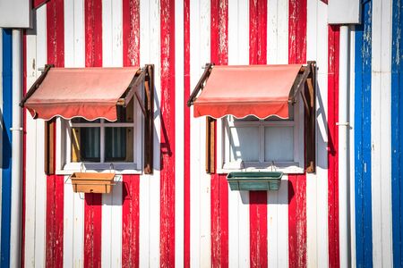 Colorful striped fishermen's houses in blue and red, Costa Nova, Aveiro, Portugalの写真素材