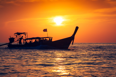 Fishing boat with sunset in phi phi islands,Thailandの写真素材