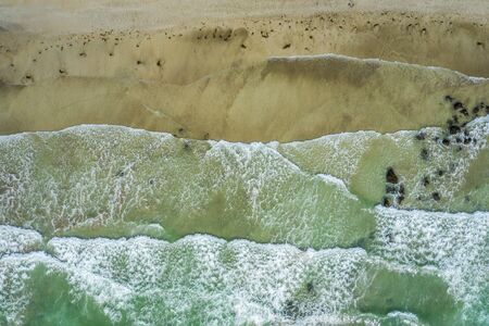 Aerial view of sandy beach and ocean with waves