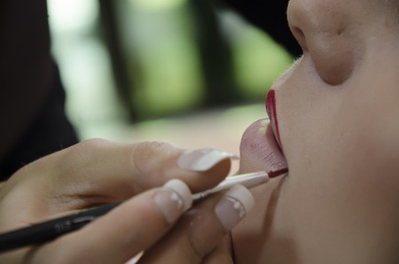 Woman in a hairdressing putting on makeupの写真素材