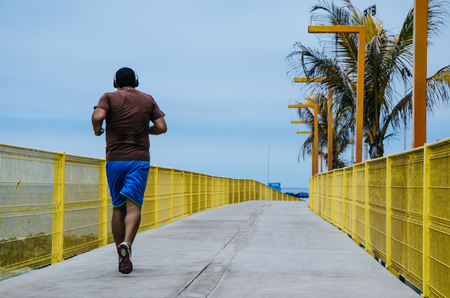 Man running along the coastline of the beachの写真素材