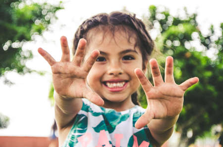 Happy girl showing her hands in the parkの写真素材
