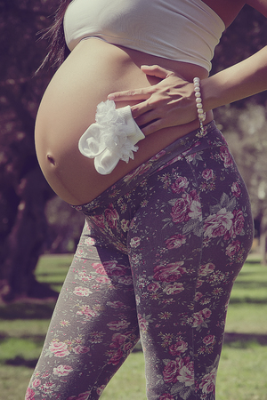 Belly of a future mother with her baby's socksの写真素材