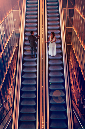 Romantic photo, groom and bride meeting on escalators