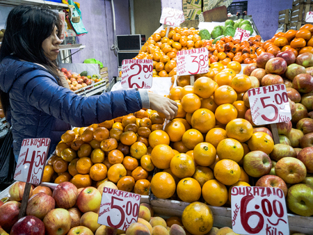 Young brunette woman buying fruits at the marketの写真素材