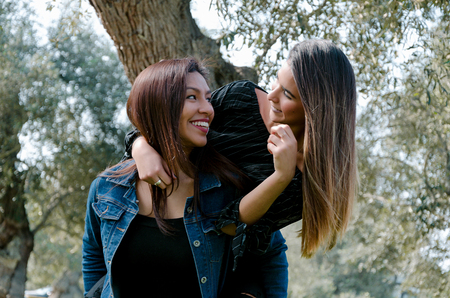 Outdoor lifestyle portrait of two best friends, smiling and having fun togetherの写真素材